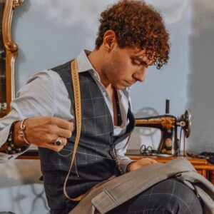 Tailor Alessandro sews during a sewing lesson with Loliv