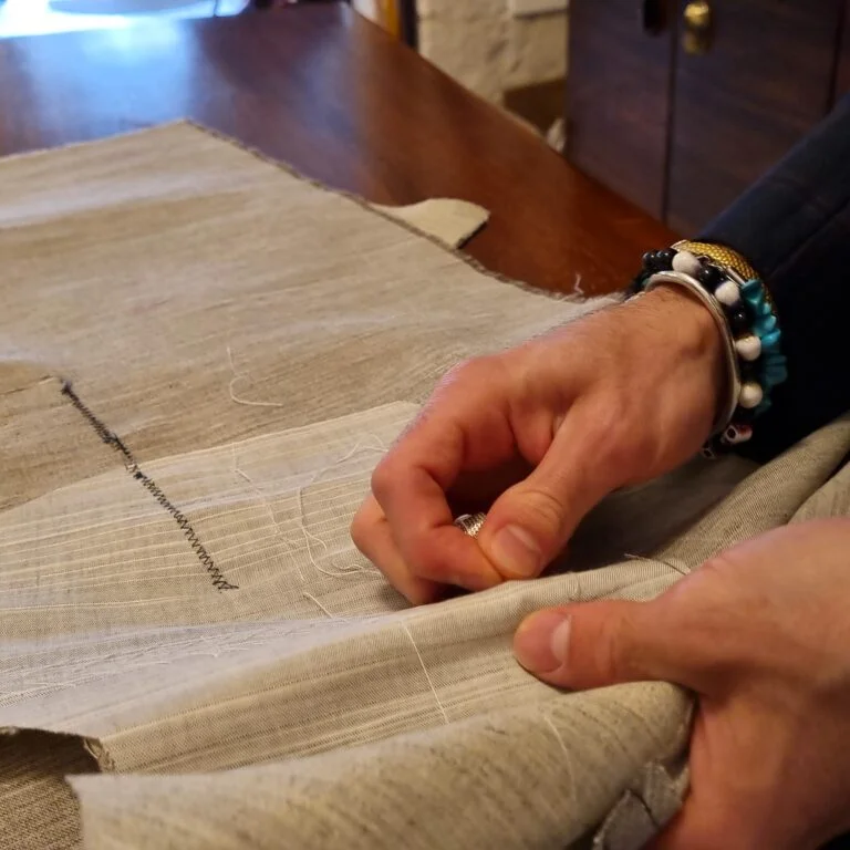 mani che cuciono durante il corso di sartoria