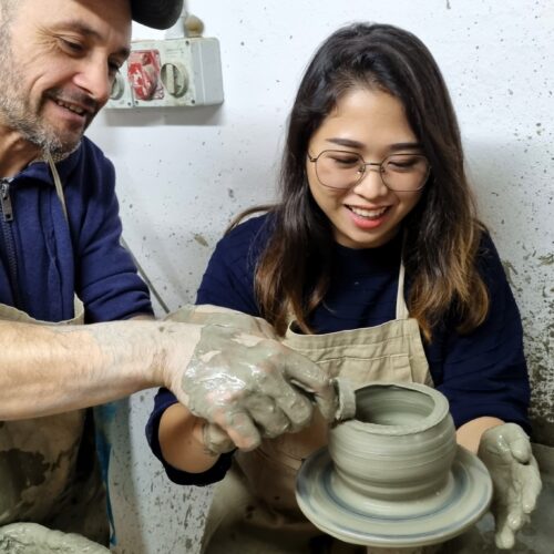 il maestro ceramista insegna come modellare l'argilla durante il corso di ceramica al tornio