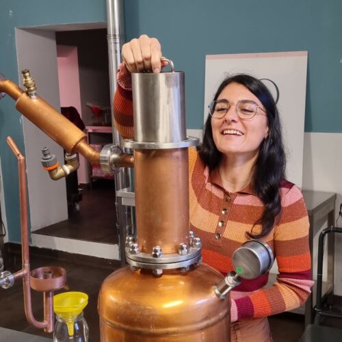 una partecipante all'esperienza prepara l'alambicco per il processo di distillazione durante l'esperienza