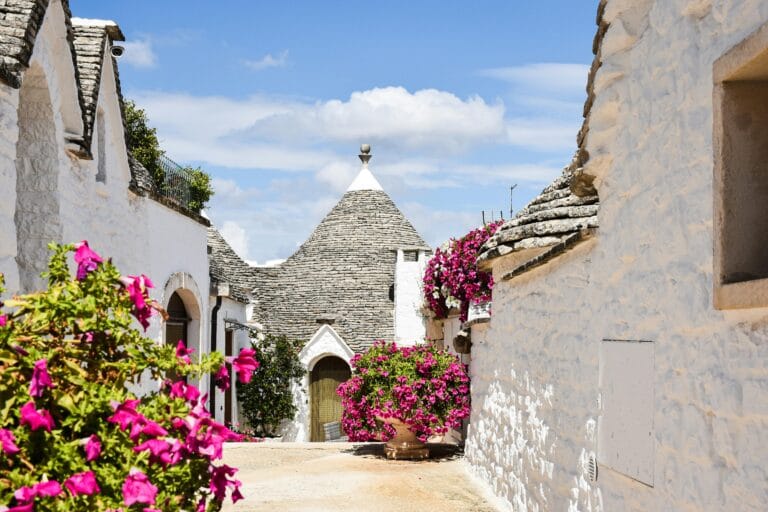 A flower-filled alley among the trulli of Alberobello, a UNESCO heritage site in Puglia