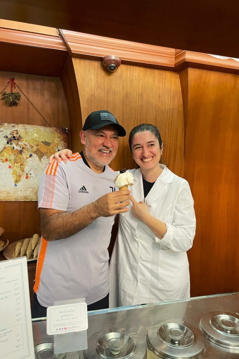 Traveller tasting artisanal gelato with the local gelato maker, discovering flavours prepared according to traditional recipes