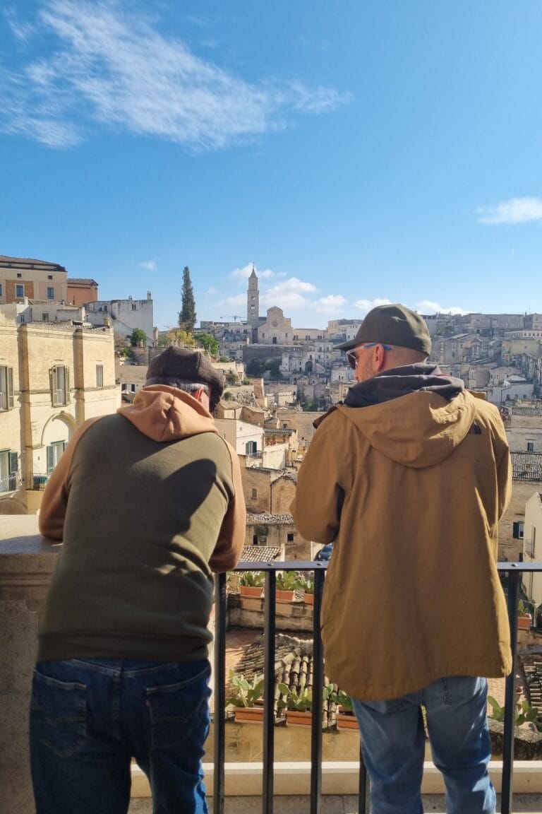 Travellers admiring the Sassi of Matera from a scenic viewpoint, taking in the city’s unique historic architecture and landscape