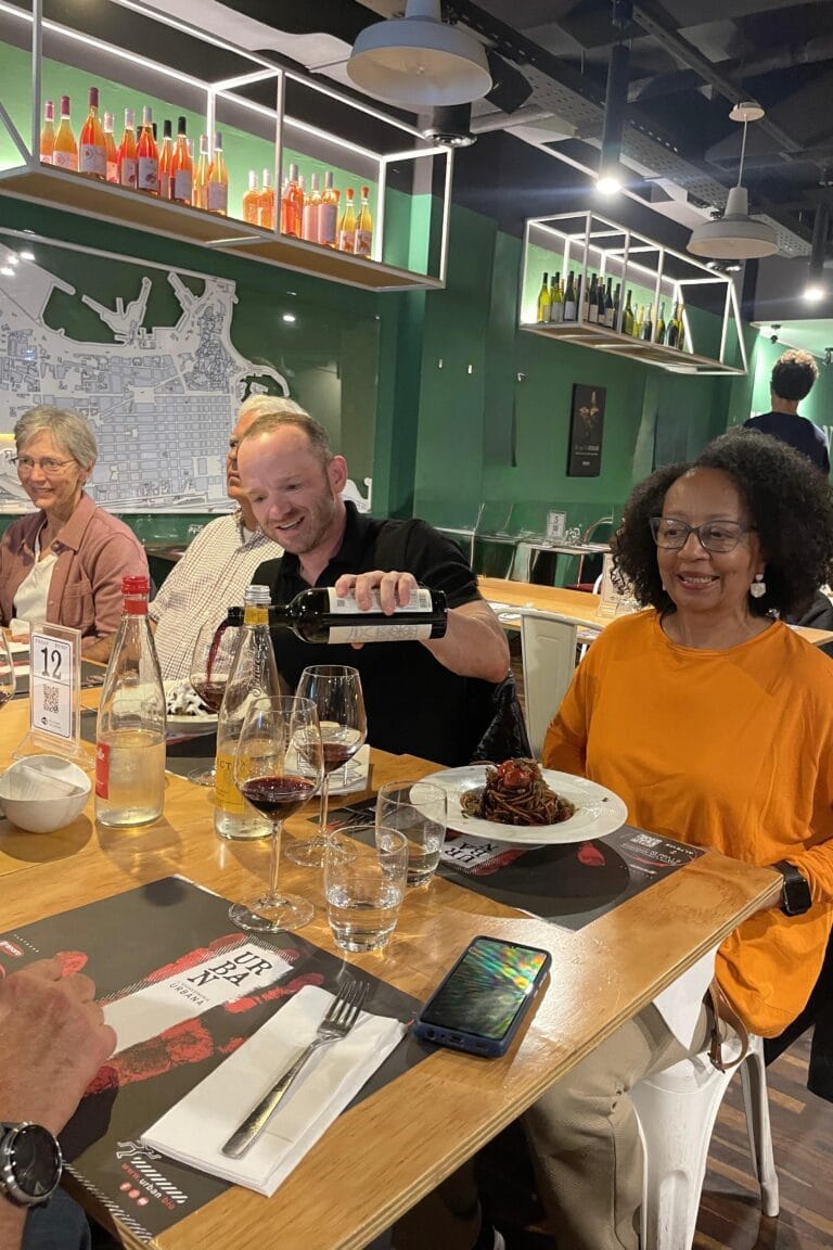 Guests seated around a table in a local restaurant, enjoying spaghetti all’assassina, one of the most iconic dishes from Bari’s culinary tradition