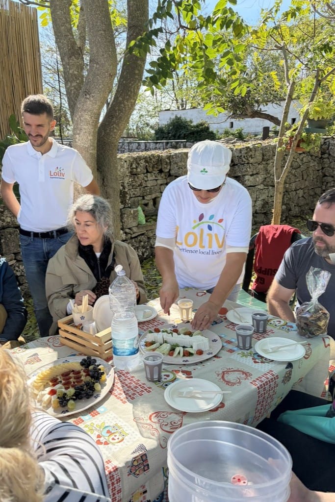 Outdoor tasting of fresh cheeses and local products in a rural Apulian setting, enjoyed during a convivial moment in a traditional masseria
