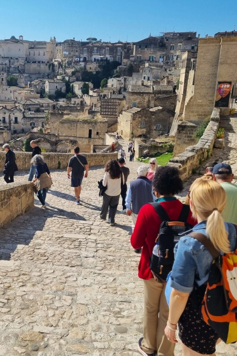 Gruppo che passeggia nei Sassi di Matera lungo una strada in pietra