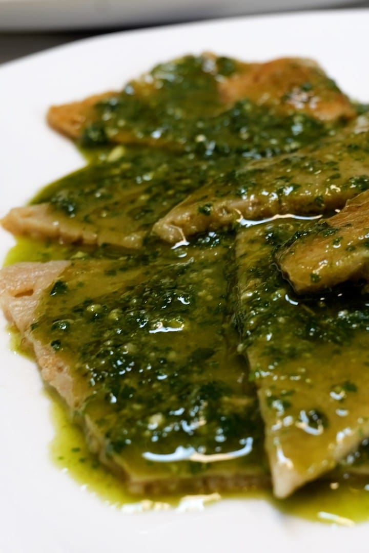 Testaroli served with pesto on a white plate