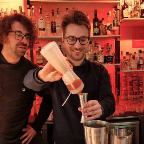 A guy learns how to measure alcohol during a cocktail making class