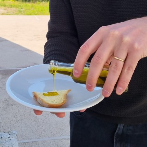 olio versato su una fetta di pane durante la degustazione degli oli di qualità