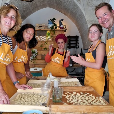 Famiglia prepara la pasta fresca durante il corso di cucina