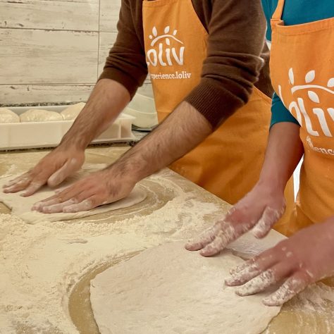 Close-up of hands shaping pizza bases in Bari pizza making class