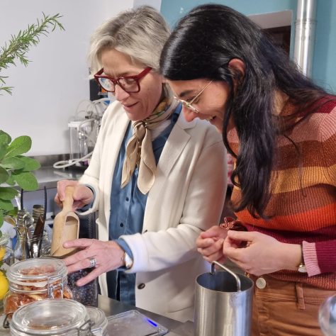 maestra distillatrice e partecipante selezionano le botaniche prima di avviare la distillazione del gin